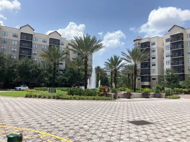 a multi story building with yard and plants
