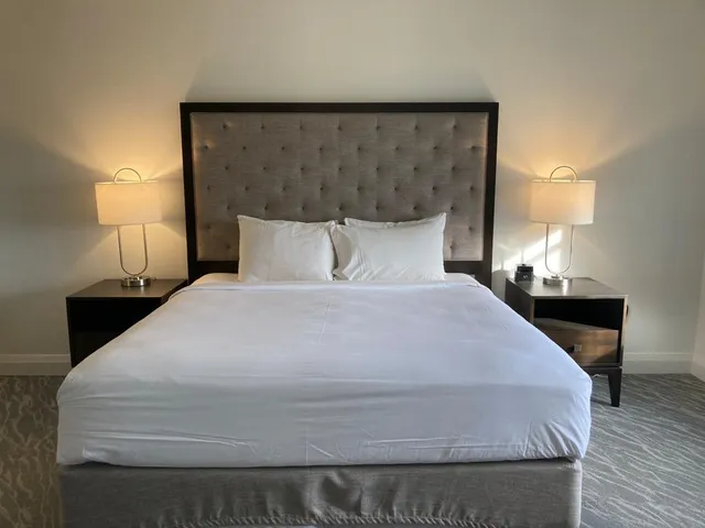 a large bed sitting in a bedroom and lamp