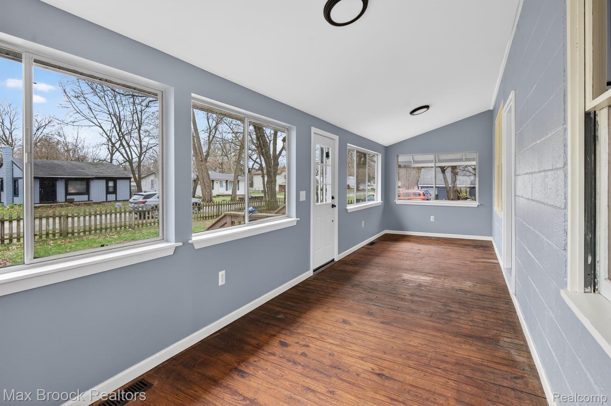 9024 Mandon Road White Lake, MI 48386 - Photo 5 of 39 Unfurnished sunroom with vaulted ceiling, wood finished floors, and a residential view