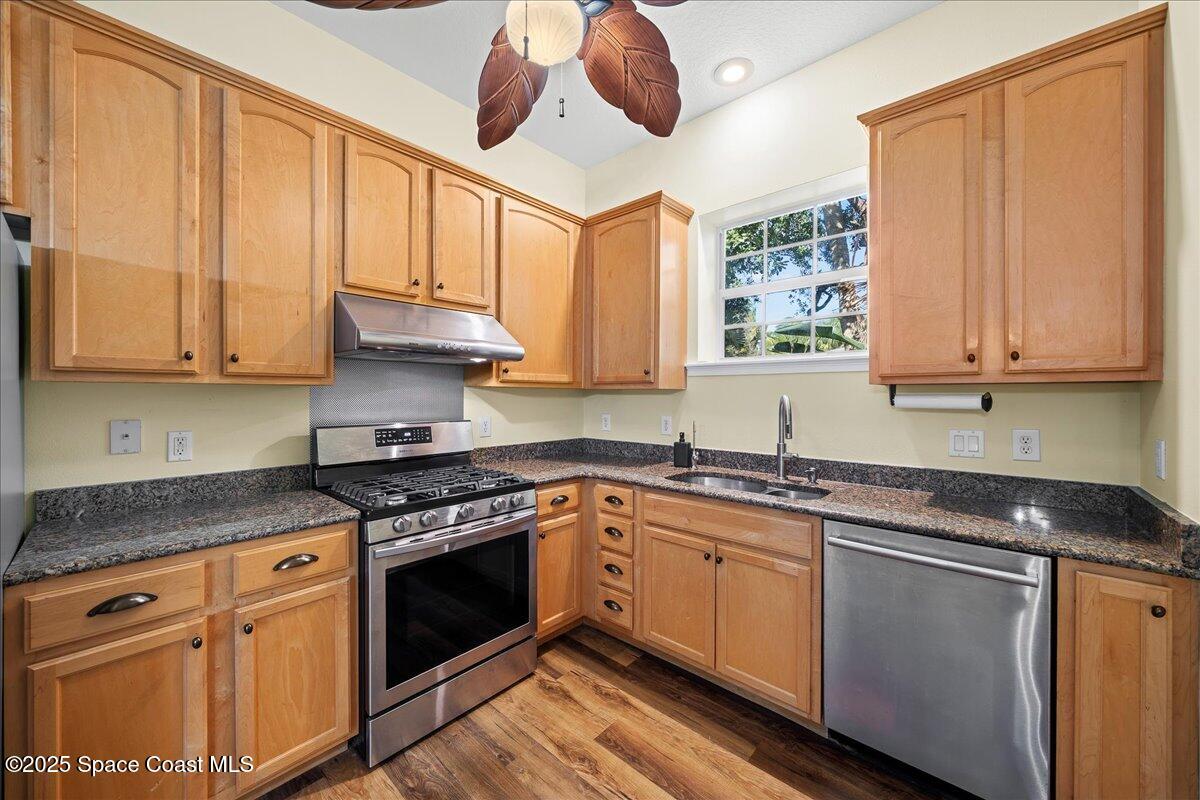 7831 Winona Road Melbourne Beach, FL 32951 - Photo 11 of 41 a kitchen with stainless steel appliances granite countertop a stove a sink and white cabinets