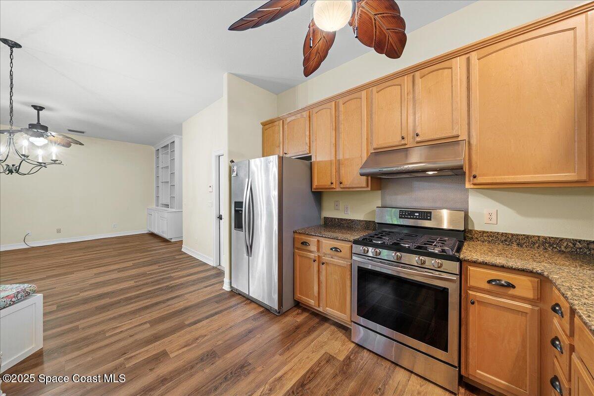 7831 Winona Road Melbourne Beach, FL 32951 - Photo 12 of 41 a kitchen with stainless steel appliances a stove a refrigerator and cabinets
