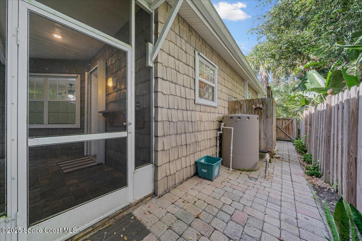7831 Winona Road Melbourne Beach, FL 32951 - Photo 30 of 41 a view of a door and chair in the patio with potted plants
