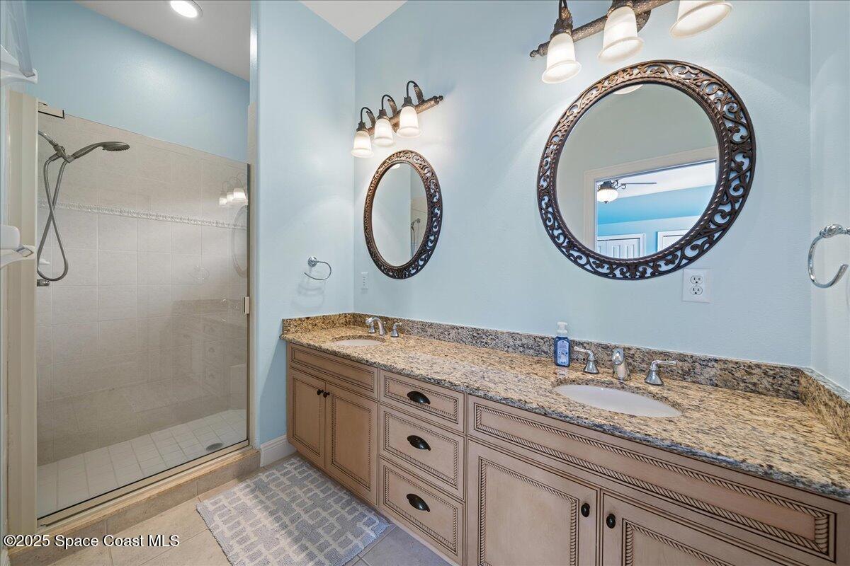 7831 Winona Road Melbourne Beach, FL 32951 - Photo 7 of 41 a bathroom with a granite countertop double vanity sink and a mirror