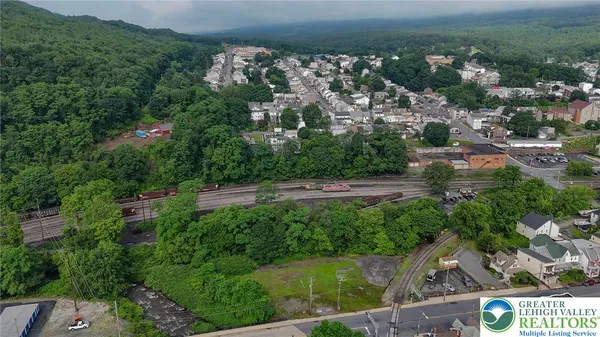 an aerial view of residential houses with outdoor space and trees