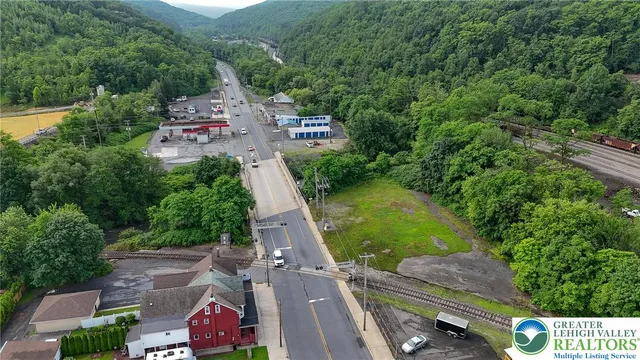 aerial view of a house with a yard and lake view