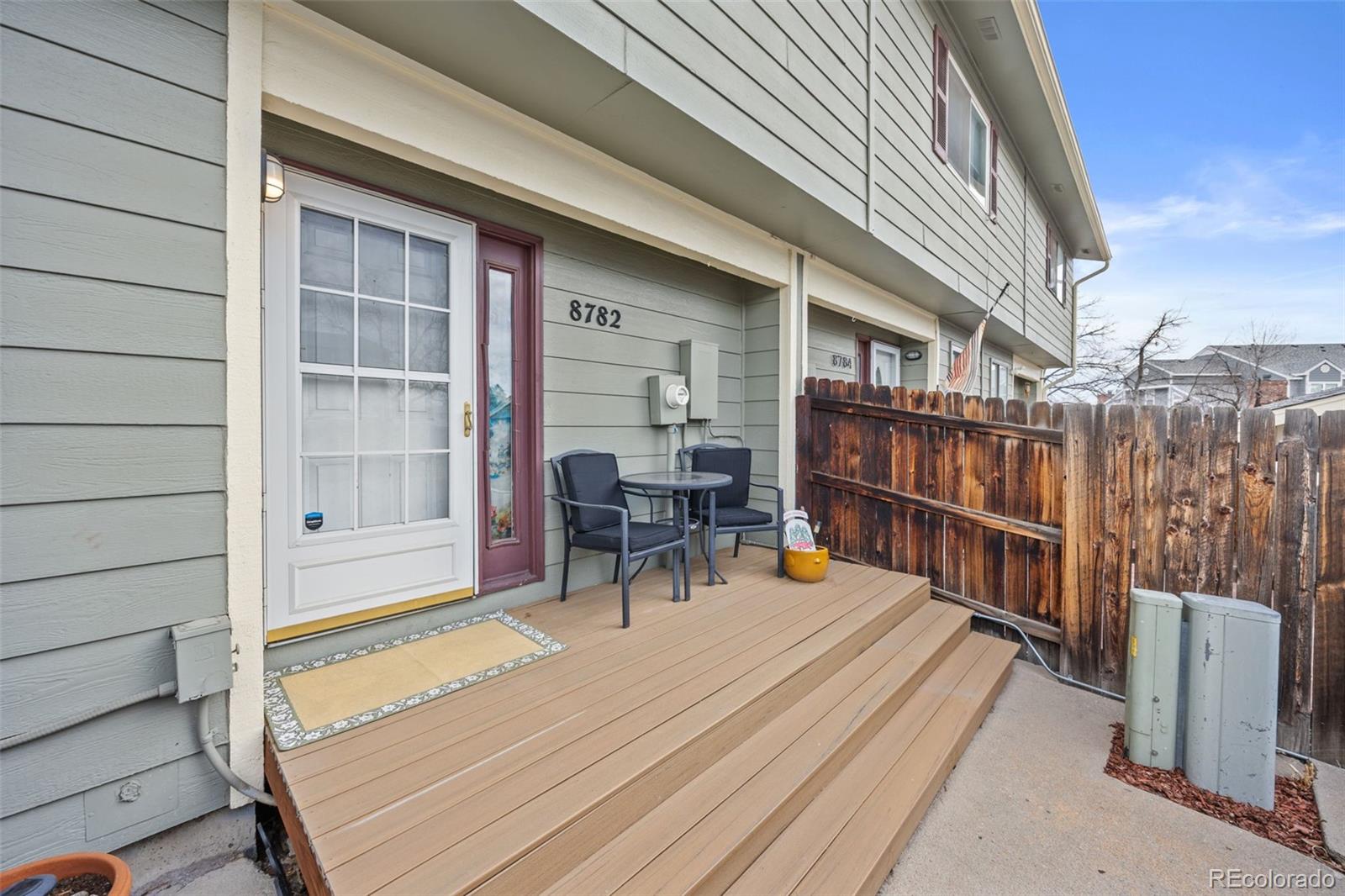 8782 Carr Loop Arvada, CO 80005 - Photo 1 of 23 a view of a patio with a table and chairs and wooden floor