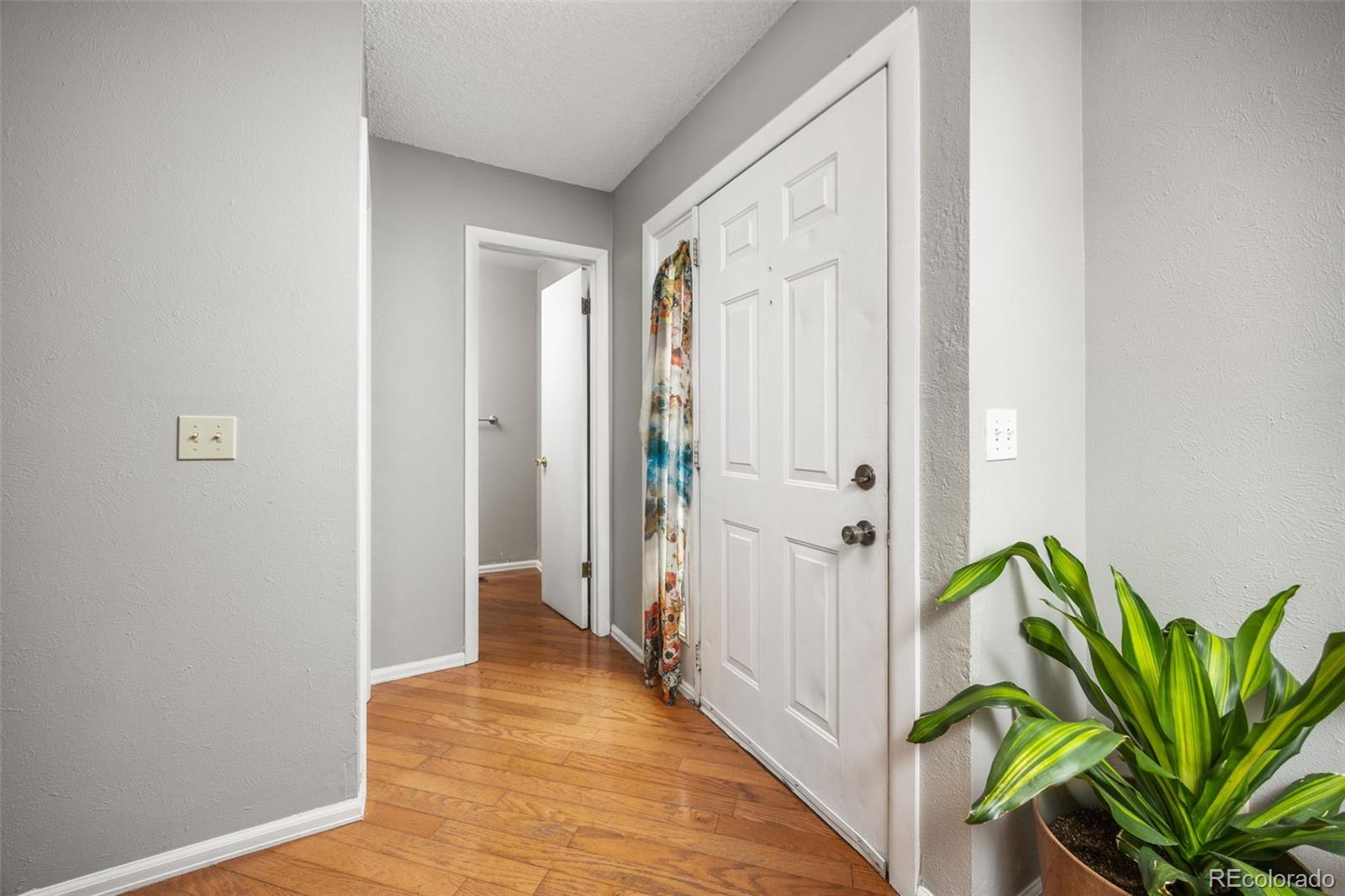 8782 Carr Loop Arvada, CO 80005 - Photo 3 of 23 a view of a hallway with wooden floor