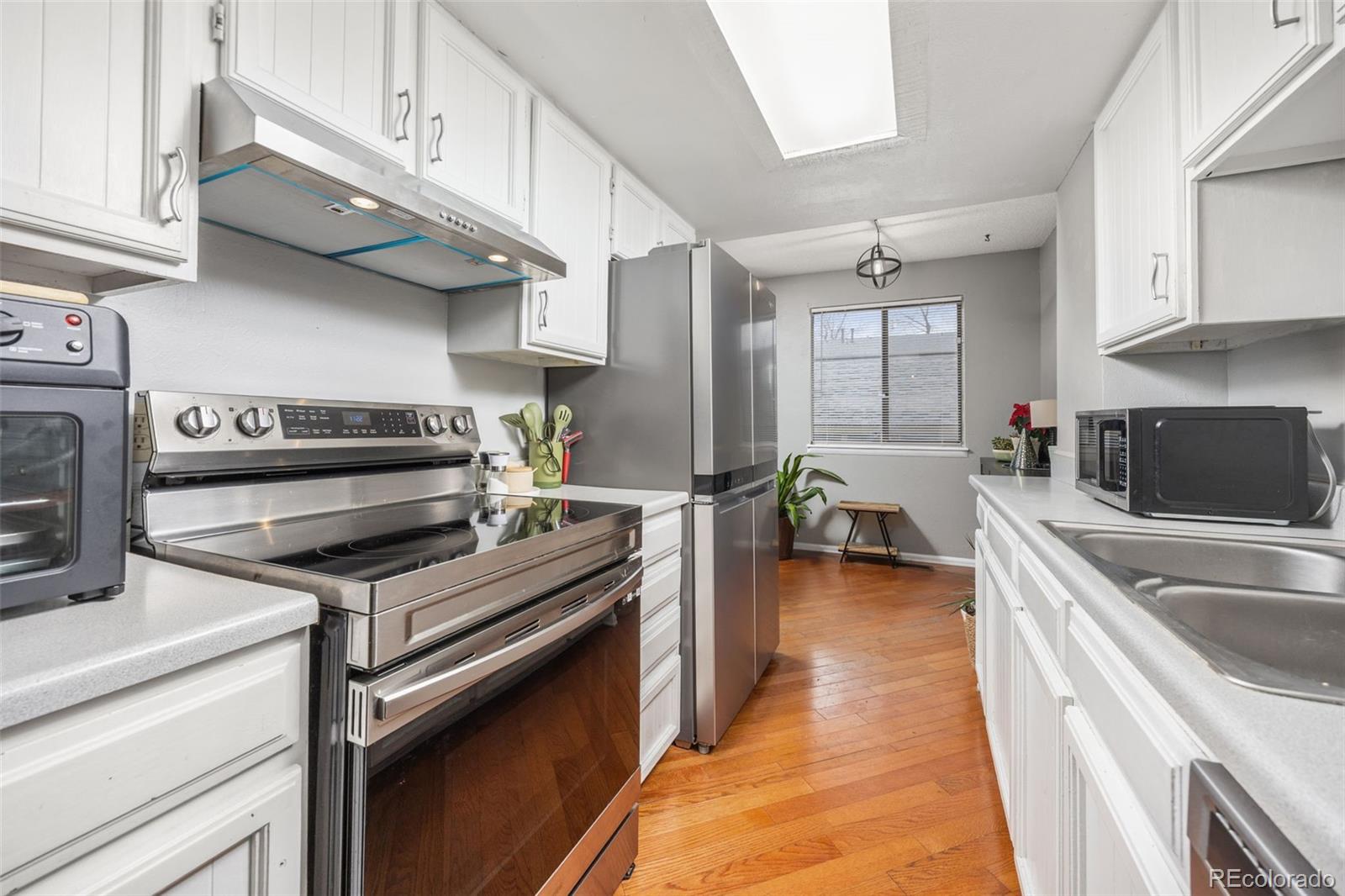 8782 Carr Loop Arvada, CO 80005 - Photo 6 of 23 a kitchen with stainless steel appliances a stove sink and cabinets