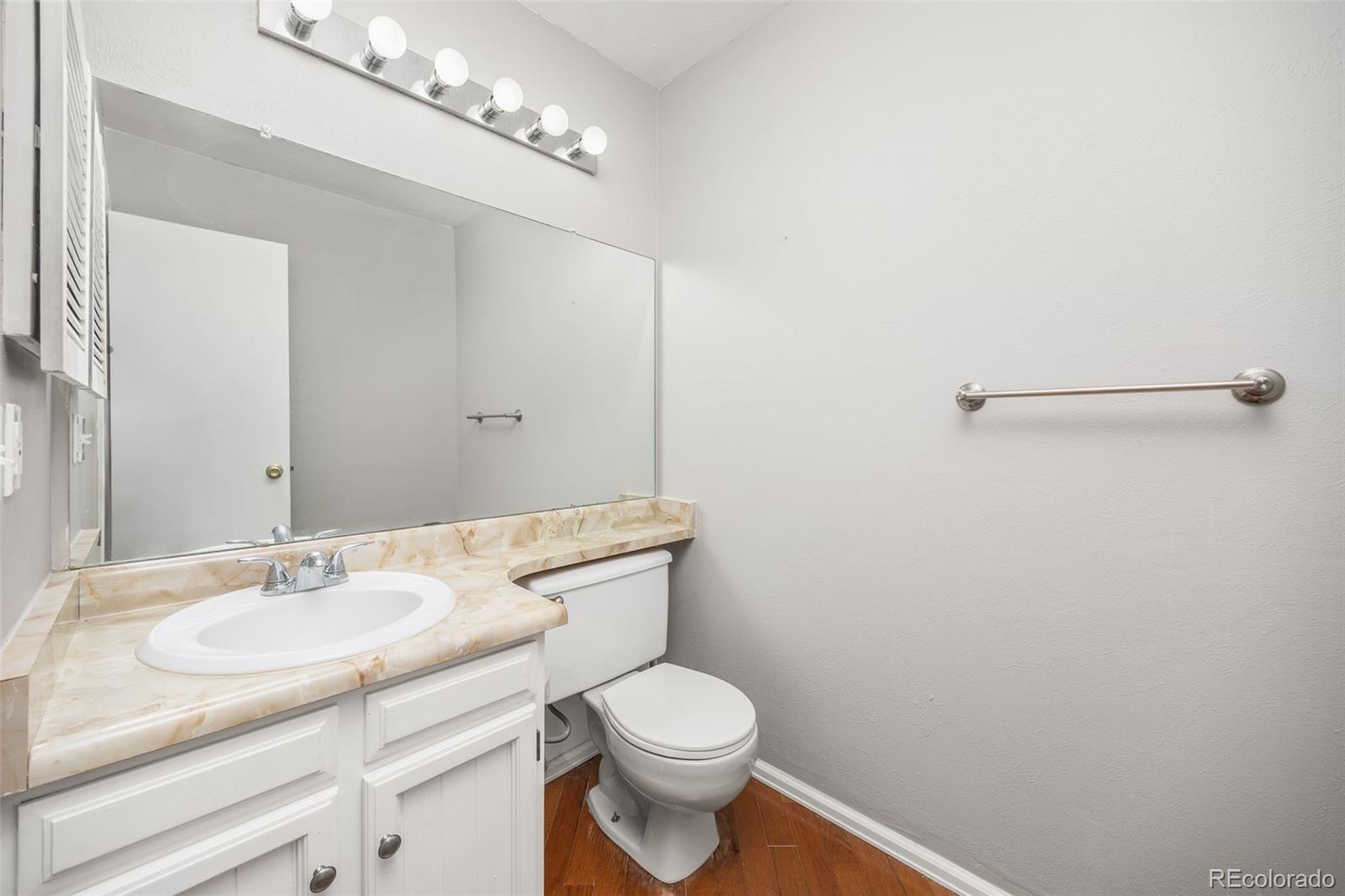 8782 Carr Loop Arvada, CO 80005 - Photo 10 of 23 a bathroom with a granite countertop sink a toilet and a mirror