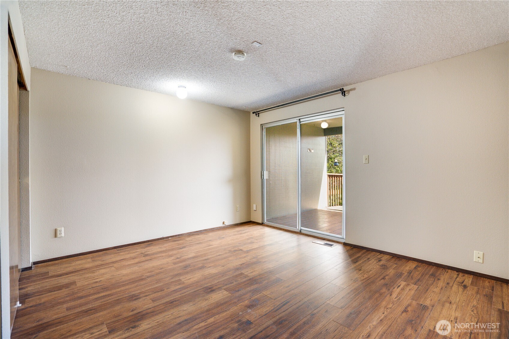 3023 Bridgeport Way West, Unit B University Place, WA 98466 - Photo 13 of 30 a view of an empty room with wooden floor and a window
