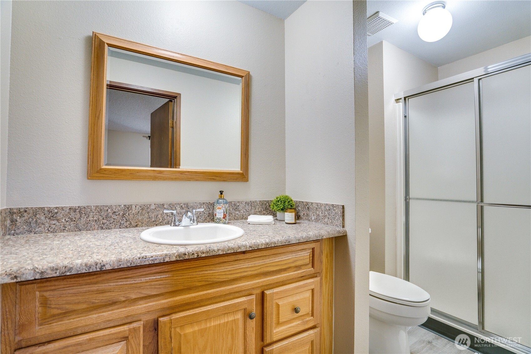 3023 Bridgeport Way West, Unit B University Place, WA 98466 - Photo 15 of 30 a bathroom with a granite countertop toilet sink and mirror