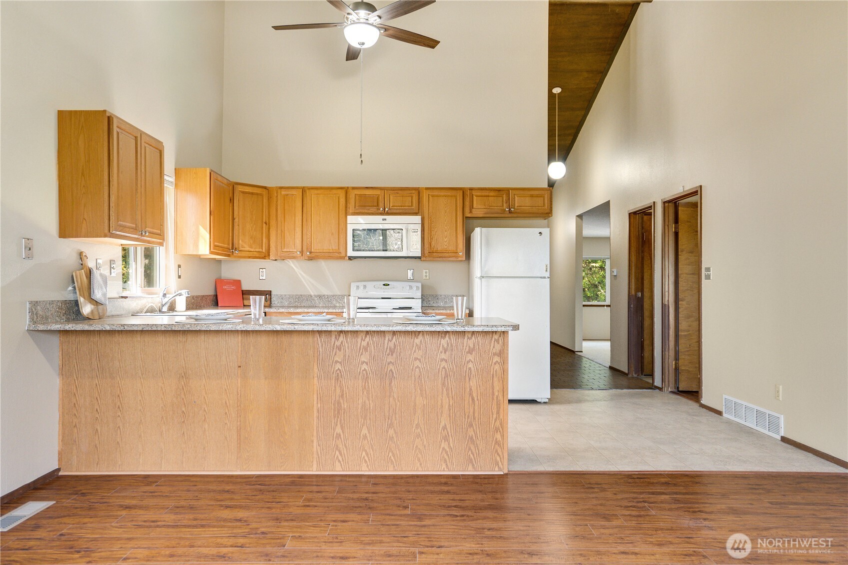3023 Bridgeport Way West, Unit B University Place, WA 98466 - Photo 6 of 30 a kitchen with stainless steel appliances granite countertop a sink a stove a refrigerator a washer dryer and a dining table
