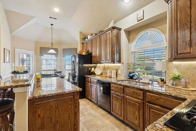 a kitchen with stainless steel appliances granite countertop a stove a sink and a microwave