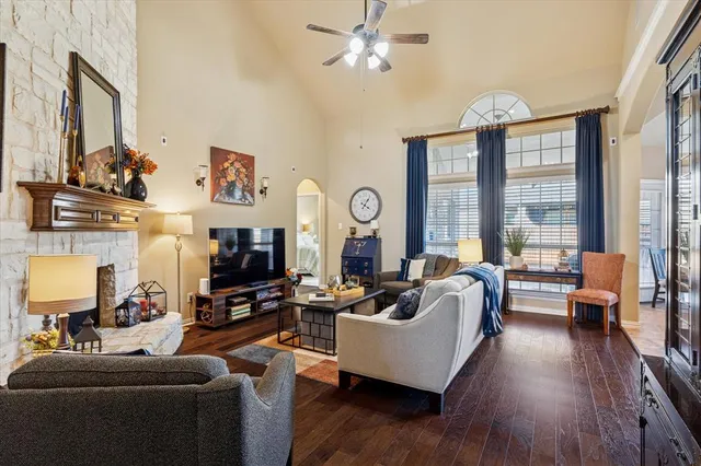 a living room with fireplace furniture and a large window