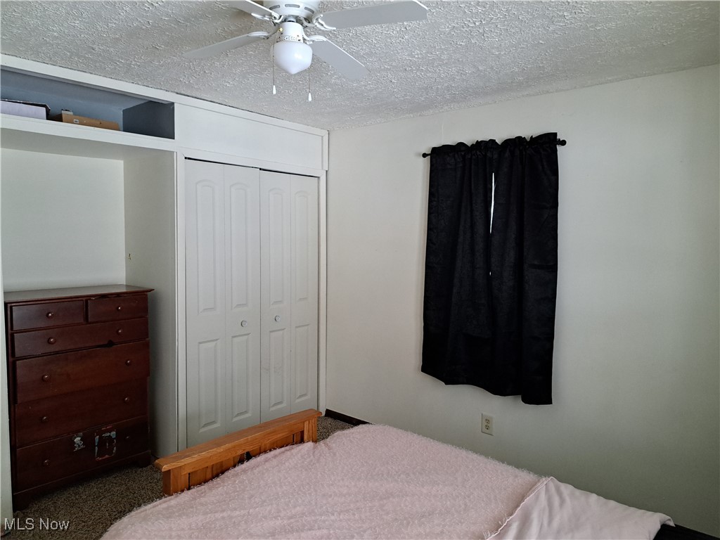 3813 State Road Vermilion, OH 44089 - Photo 27 of 28 Bedroom featuring a closet, carpet, ceiling fan, and a textured ceiling