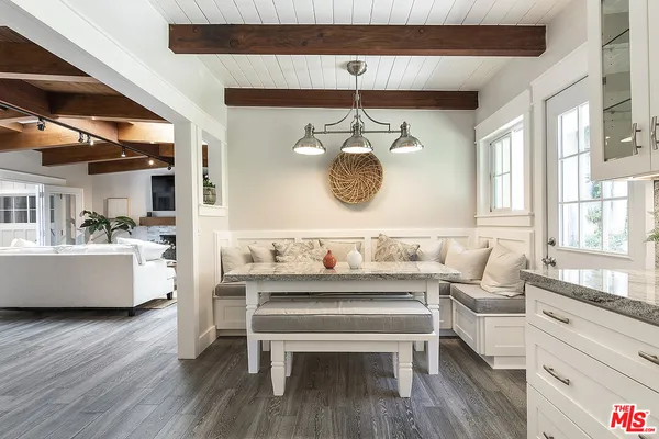a living room with a table chairs and a large window