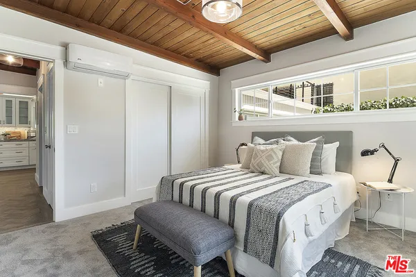 a large bed sitting in a bedroom next to a window