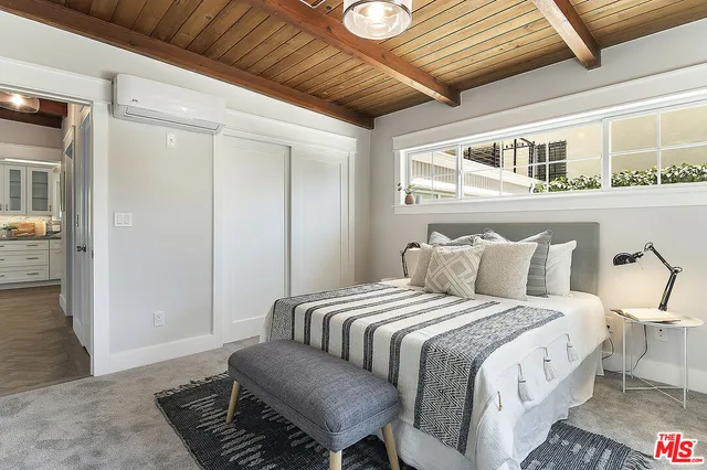 a large bed sitting in a bedroom next to a window