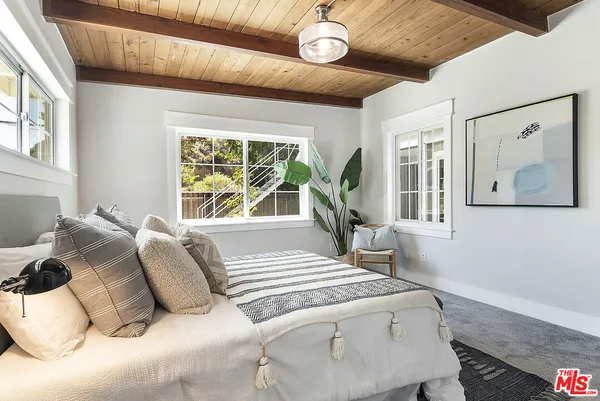 a bed sitting in a bedroom next to a window
