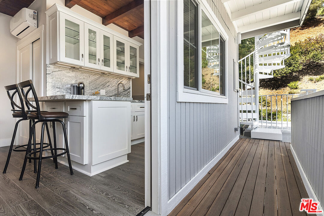 3908-a Las Flores Canyon Road Malibu, CA 90265 - Photo 39 of 60 a view of a balcony with chairs and wooden floor