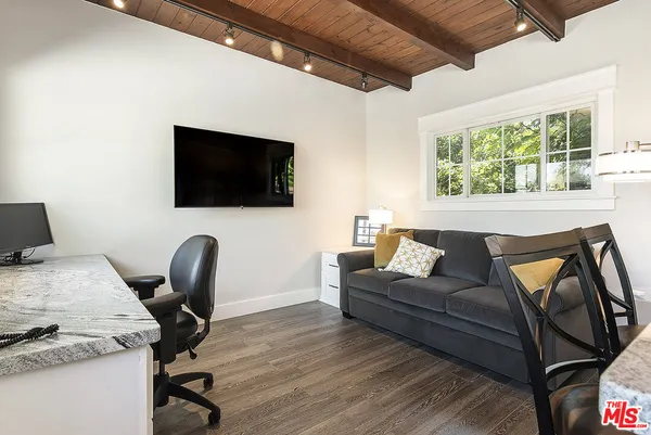 a kitchen with stainless steel appliances granite countertop a kitchen island hardwood floor and a refrigerator