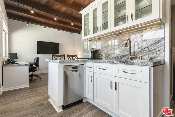 a view of patio with chairs and table under an umbrella