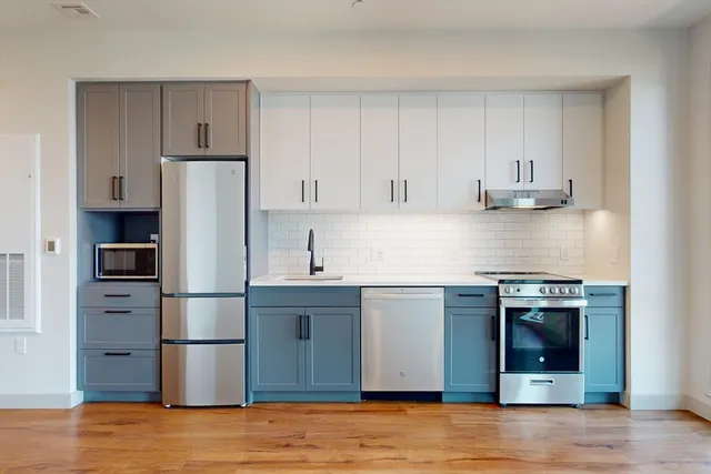 a kitchen with stainless steel appliances granite countertop a refrigerator and a stove