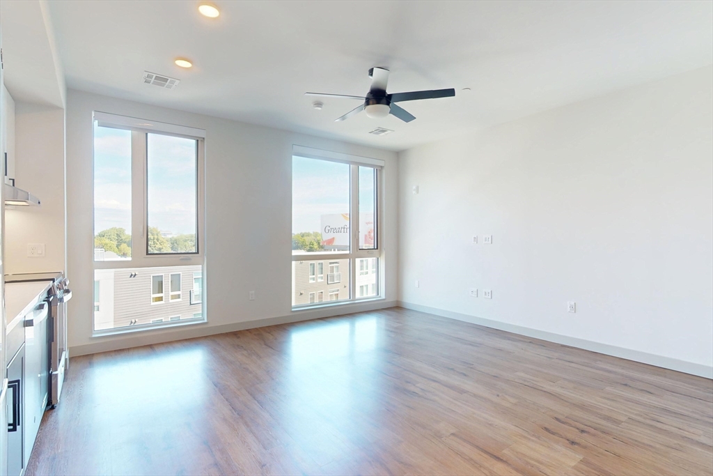 80 Rugg Road, Unit 1227 Boston, MA 02134 - Photo 6 of 13 a view of an empty room with a window and wooden floor
