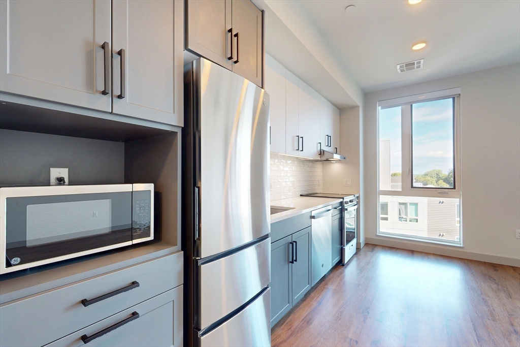 80 Rugg Road, Unit 1227 Boston, MA 02134 - Photo 7 of 13 a kitchen with stainless steel appliances a stove microwave and sink