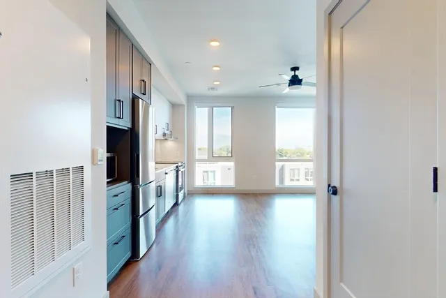 a view of a hallway with wooden floor and windows