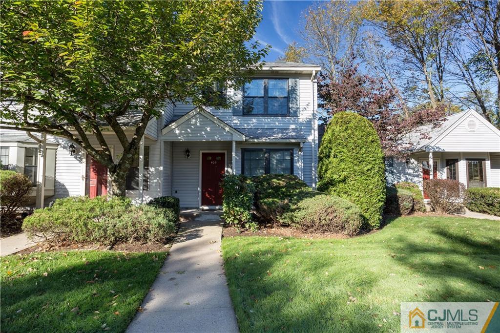 a front view of a house with a yard and potted plants