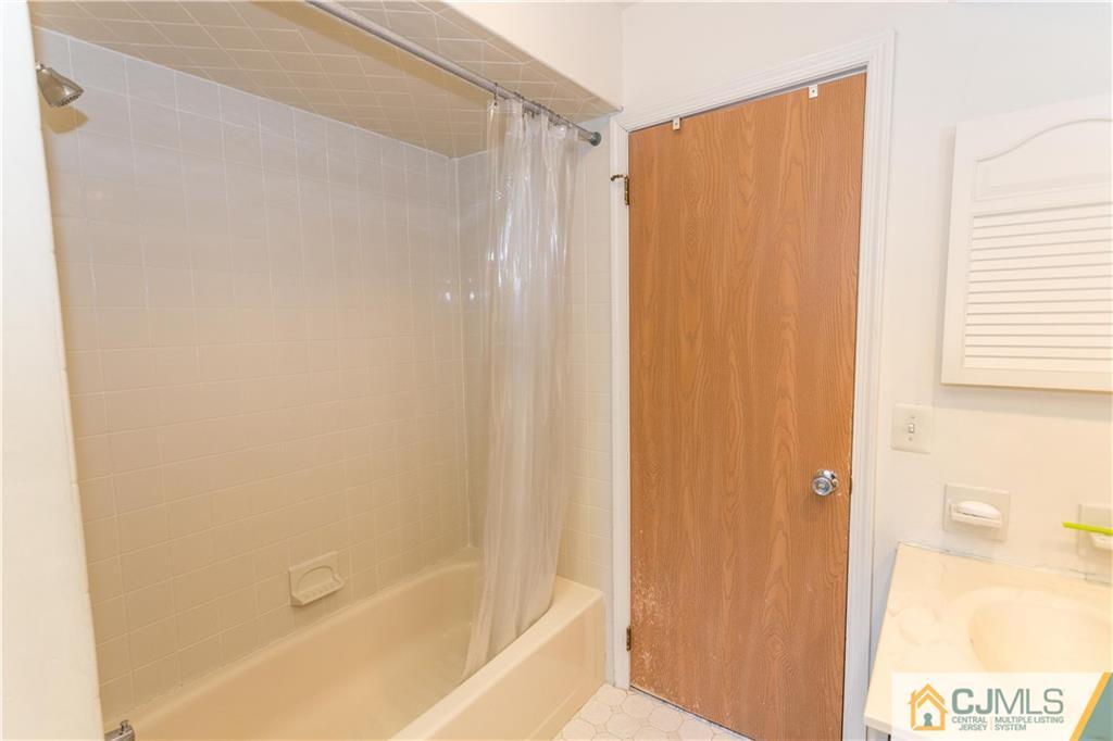 405 Maplecrest Road, Unit 405 Edison, NJ 08820 - Photo 19 of 33 a bathroom with a shower curtain and a window