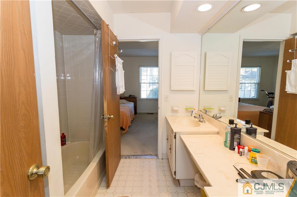 405 Maplecrest Road, Unit 405 Edison, NJ 08820 - Photo 20 of 33 a bathroom with a tub sink vanity and mirror