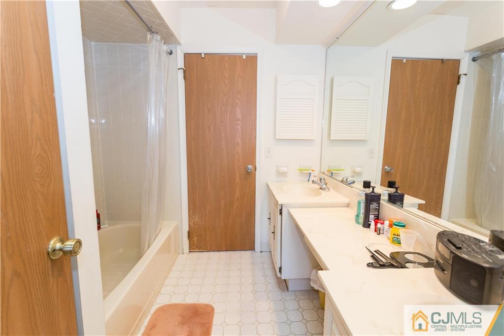 405 Maplecrest Road, Unit 405 Edison, NJ 08820 - Photo 22 of 33 a bathroom with a sink a tub and a mirror