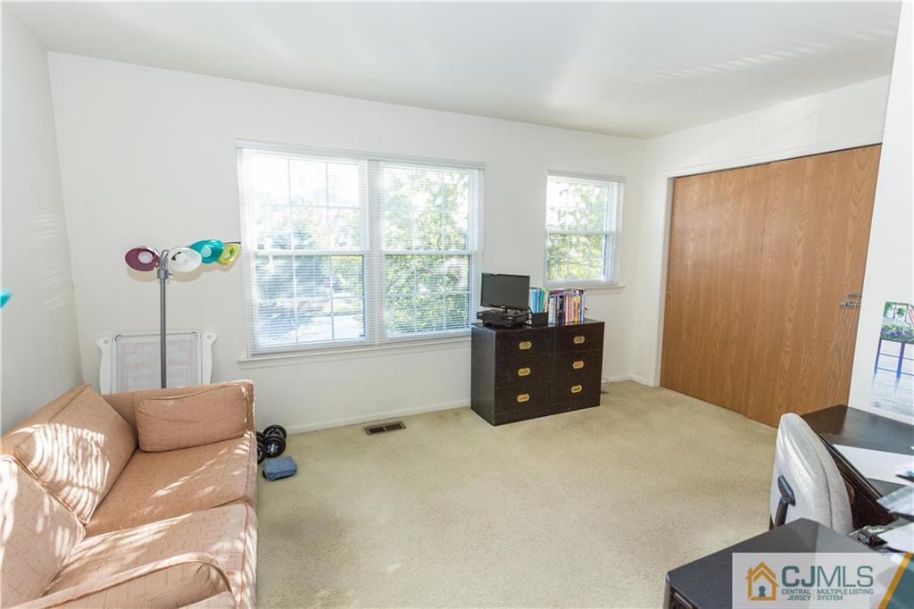 405 Maplecrest Road, Unit 405 Edison, NJ 08820 - Photo 25 of 33 a bed room with a bed and a chair