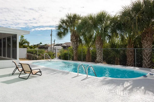 a view of a backyard with swimming pool and furniture