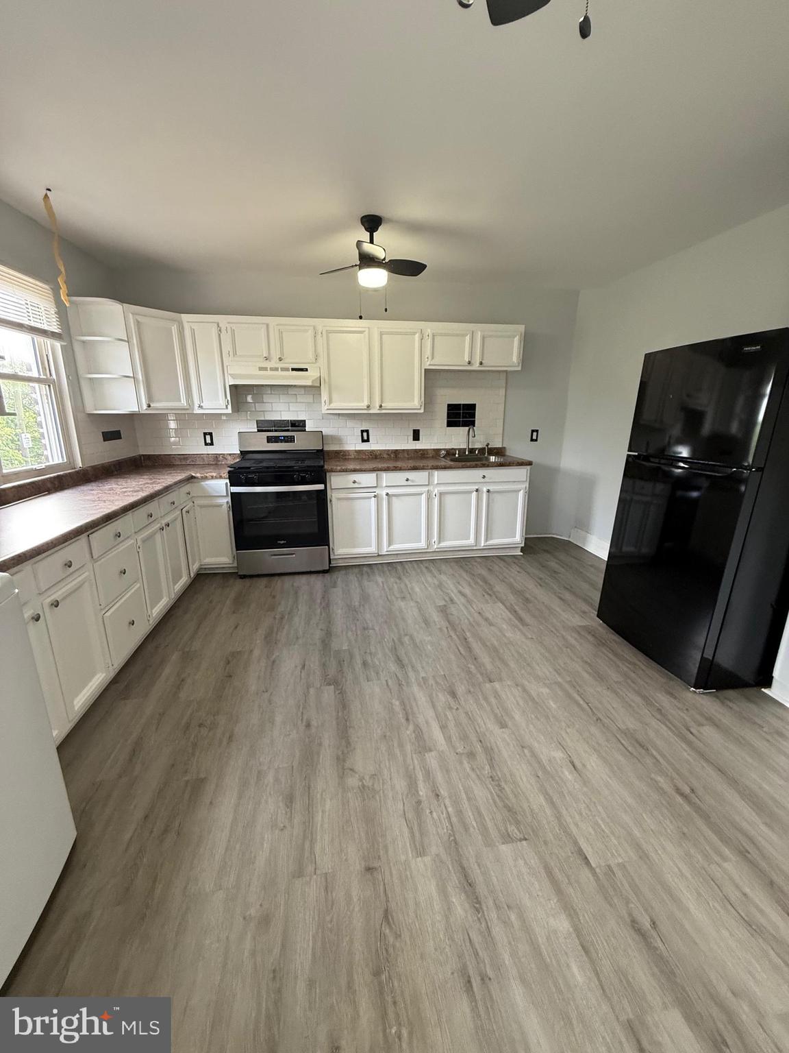 1300 South Merrimac Road Camden, NJ 08104 - Photo 7 of 25 a kitchen with stainless steel appliances kitchen island granite countertop a sink cabinets and wooden floor
