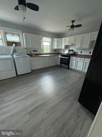 a large kitchen with cabinets and wooden floor