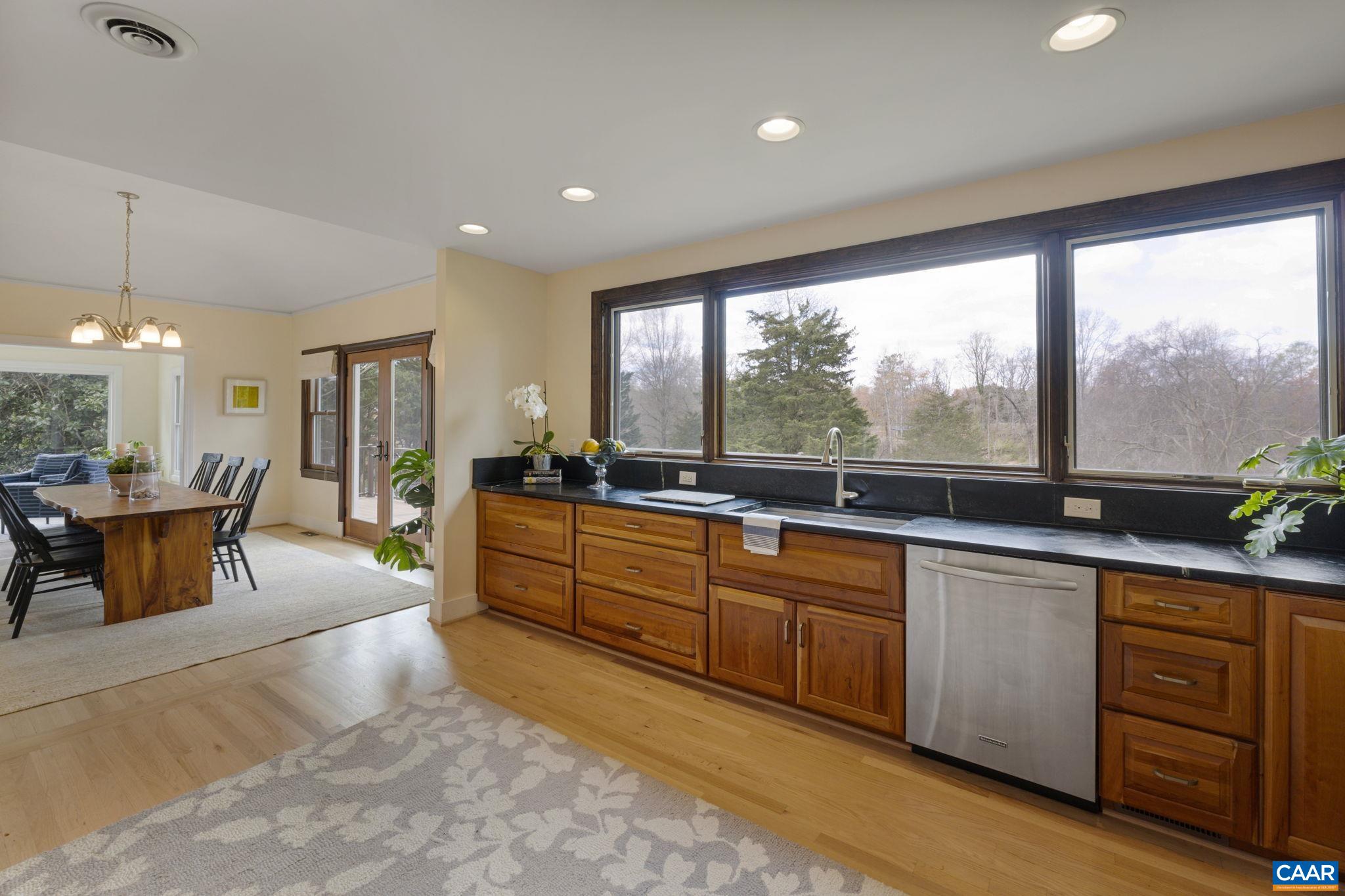 570 Rodes Drive Charlottesville, VA 22903 - Photo 22 of 75 a large kitchen with kitchen island granite countertop a large window and stainless steel appliances