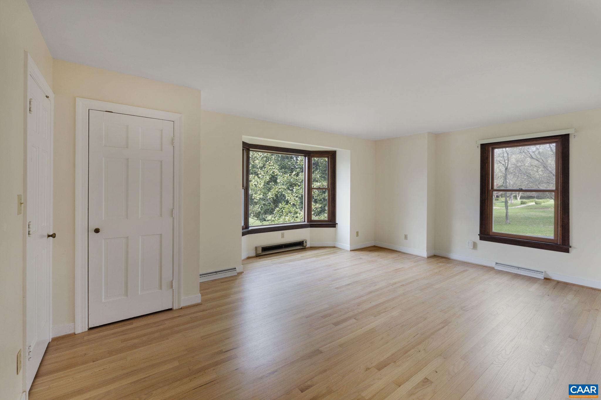 570 Rodes Drive Charlottesville, VA 22903 - Photo 32 of 75 an empty room with wooden floor and windows