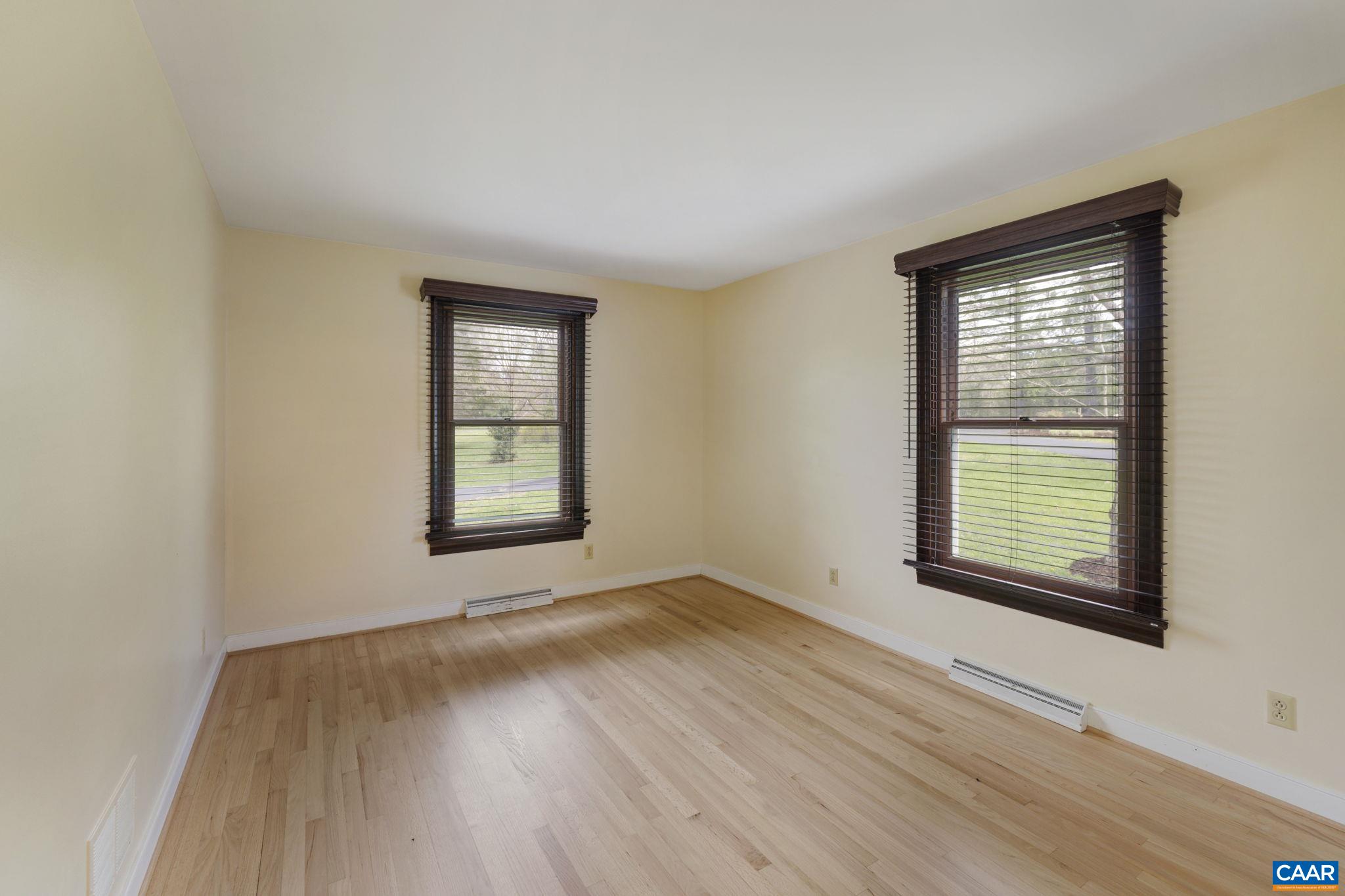 570 Rodes Drive Charlottesville, VA 22903 - Photo 36 of 75 a view of an empty room with wooden floor and a window
