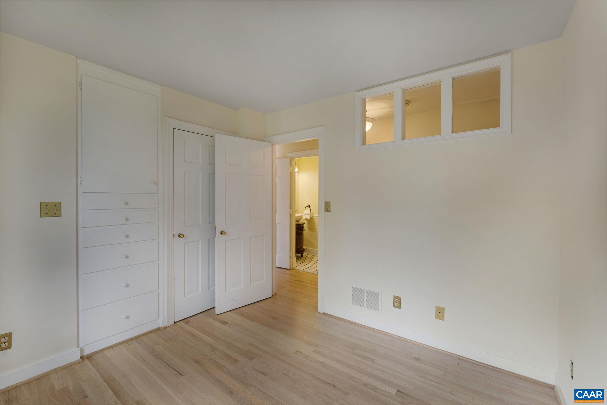 570 Rodes Drive Charlottesville, VA 22903 - Photo 38 of 75 a view of an empty room with wooden floor and a window