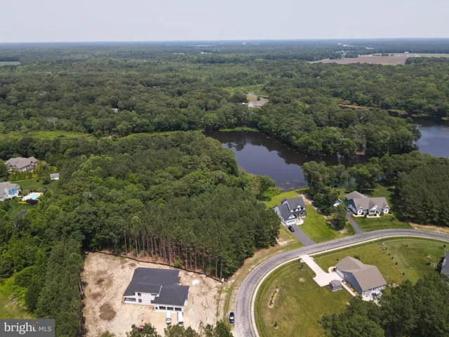 an aerial view of a house with a yard and lake view