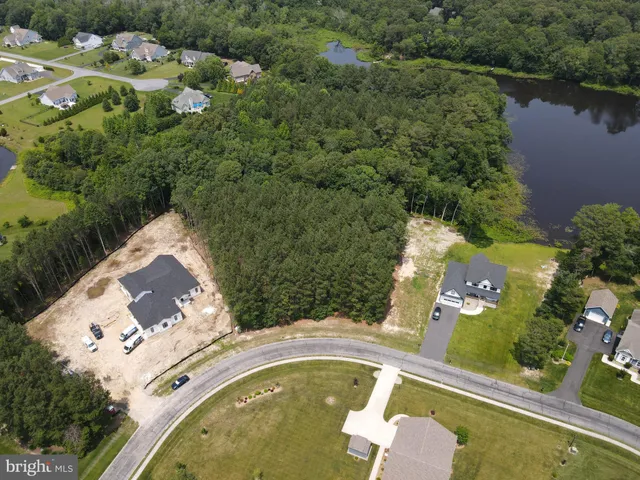 an aerial view of a house with a yard and lake view