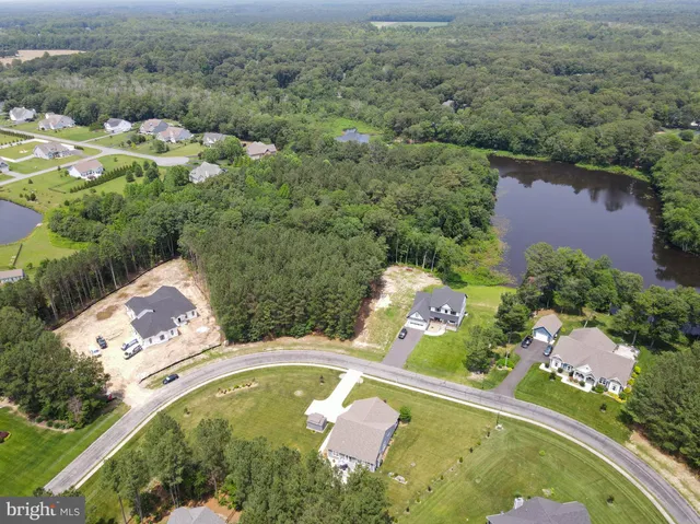 an aerial view of a house with a yard and lake view