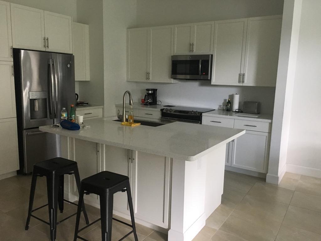 23045 Clear Echo Drive, Unit 76 Boca Raton, FL 33433 - Photo 11 of 35 a kitchen with stainless steel appliances a stove a sink refrigerator and microwave