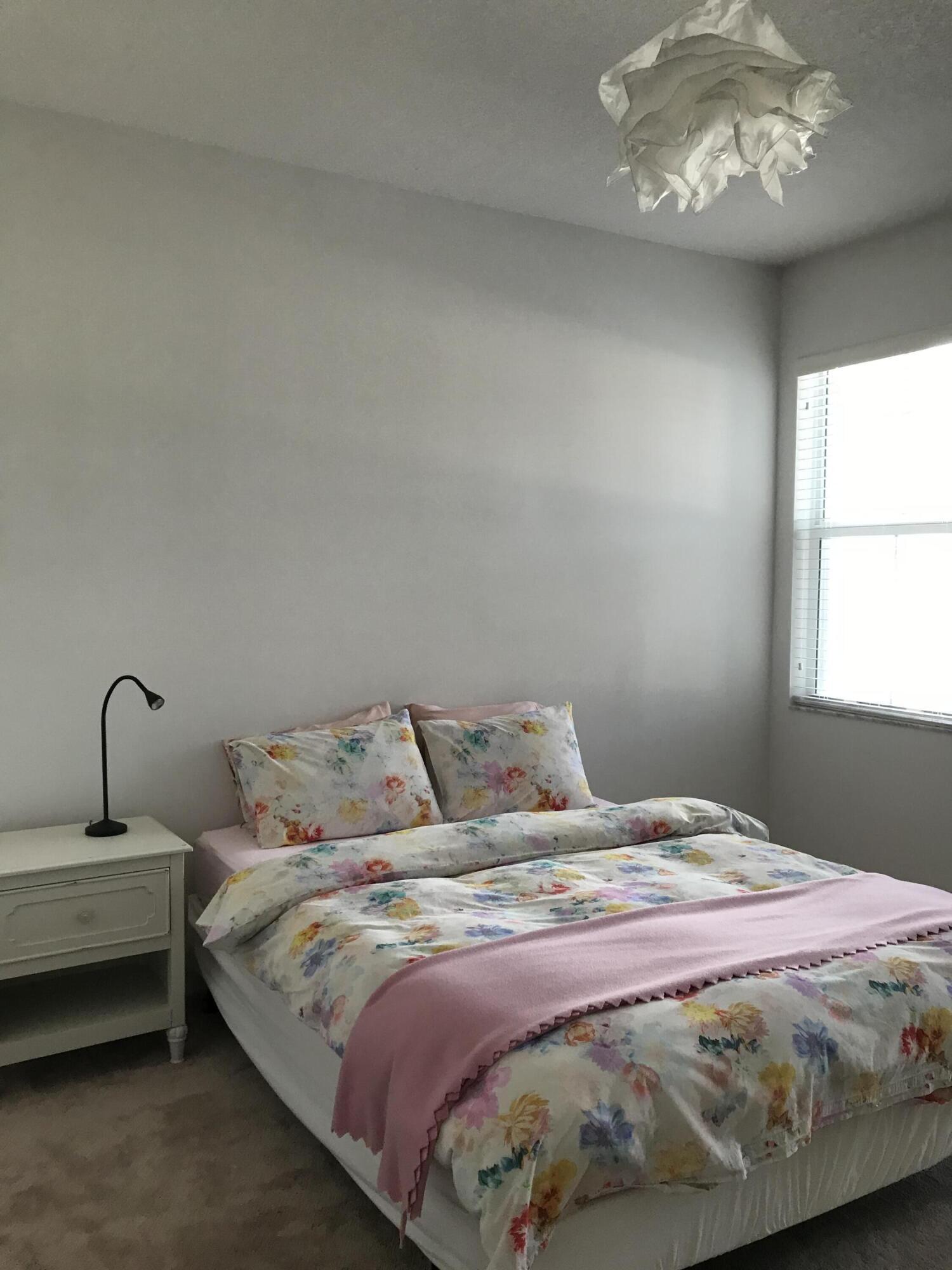 23045 Clear Echo Drive, Unit 76 Boca Raton, FL 33433 - Photo 28 of 35 a bedroom with a bed and a table