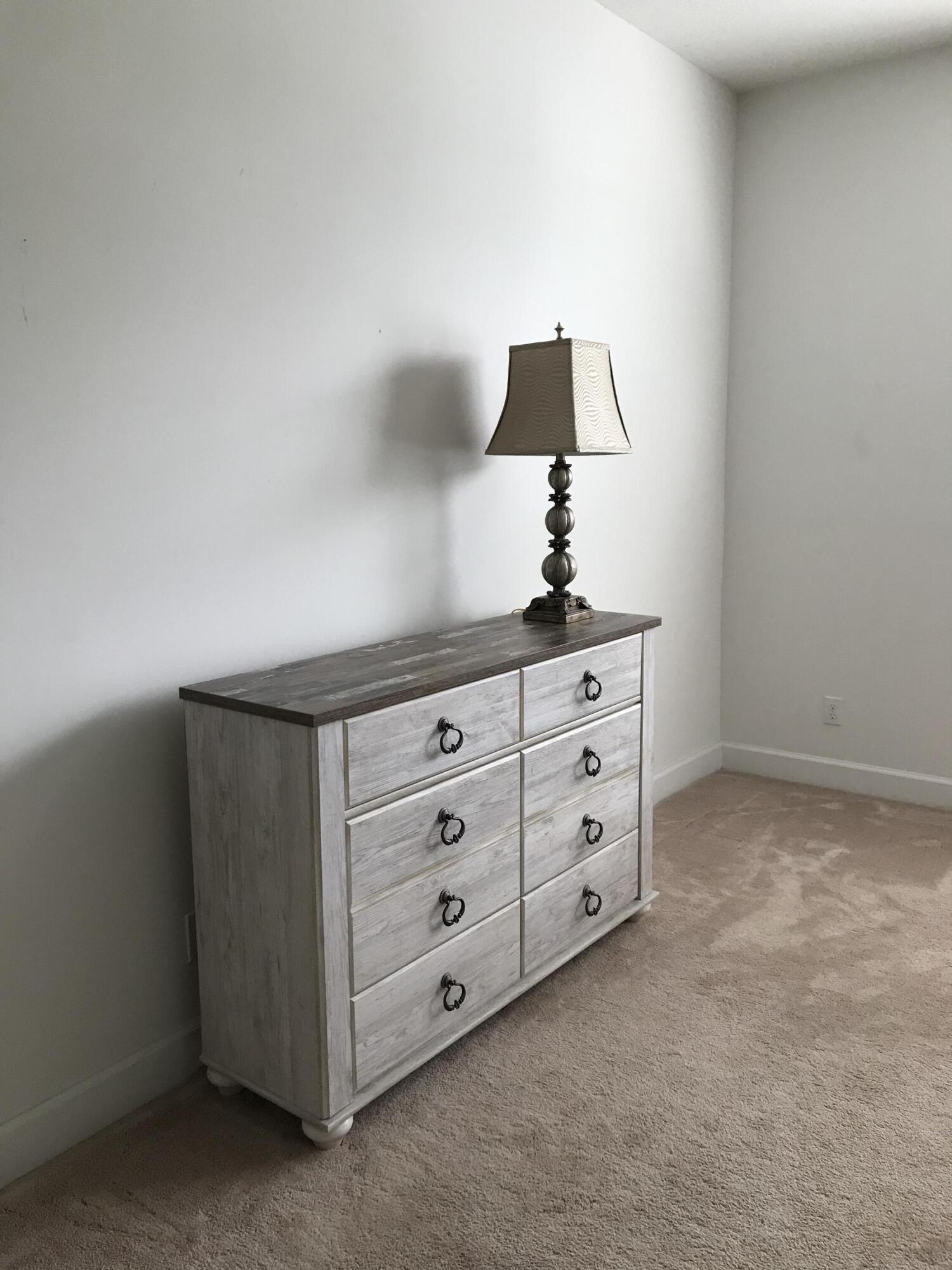 23045 Clear Echo Drive, Unit 76 Boca Raton, FL 33433 - Photo 29 of 35 a room with a lamp dresser and a lamp