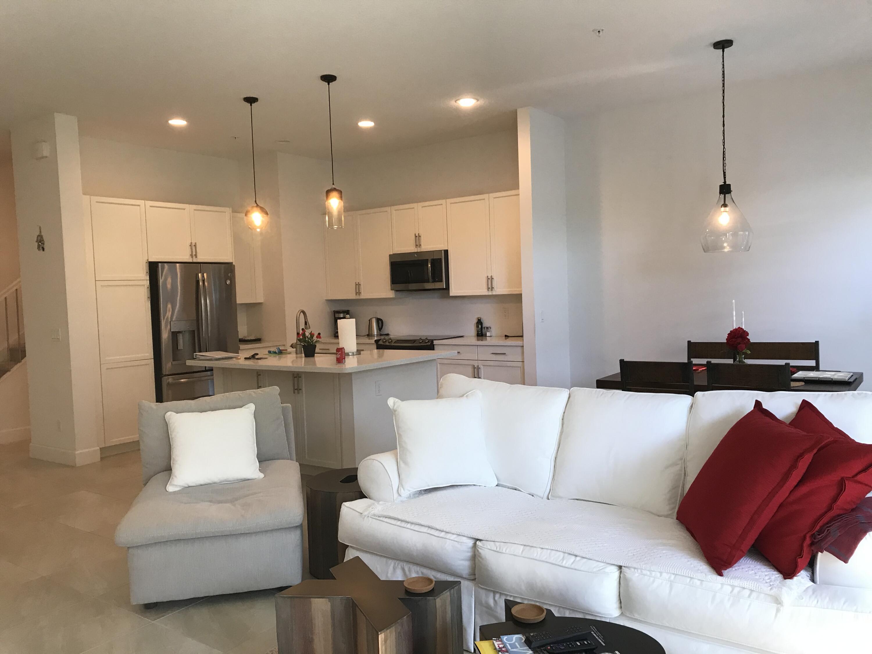 23045 Clear Echo Drive, Unit 76 Boca Raton, FL 33433 - Photo 9 of 35 a living room with a couch and a view of kitchen