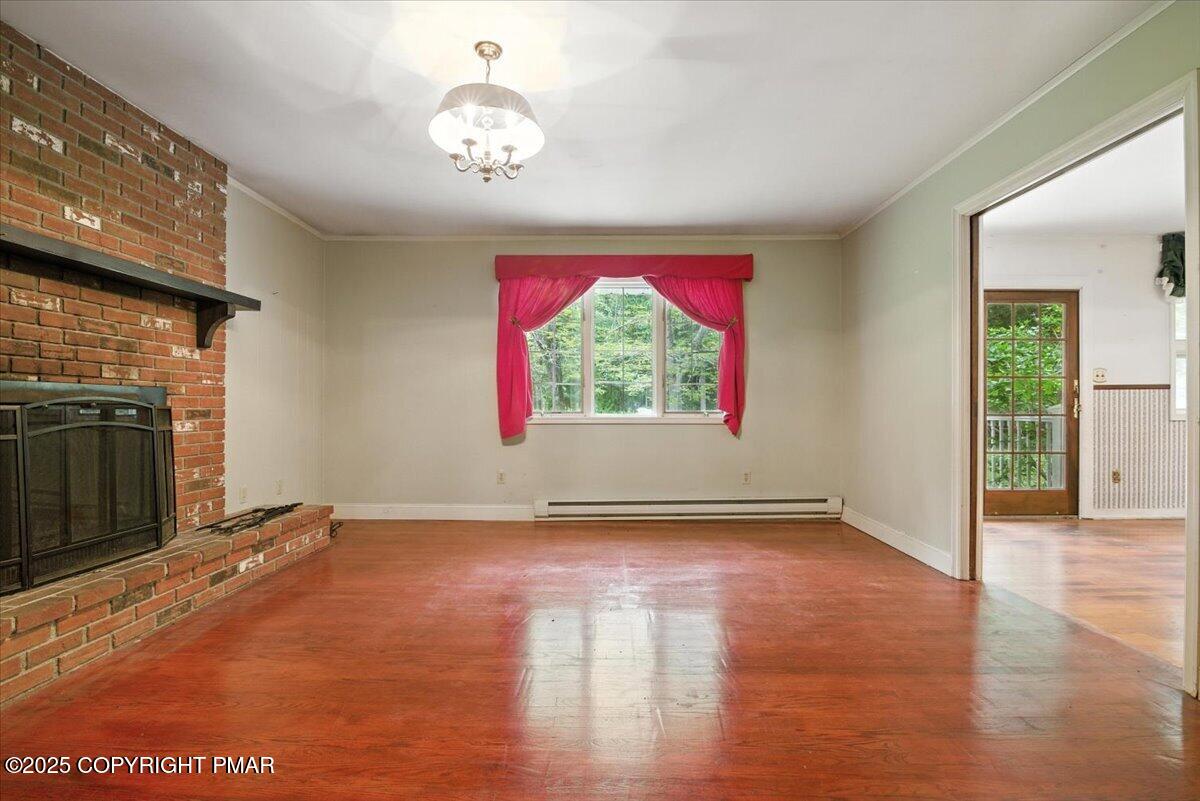 142 Pine Grove Road Kunkletown, PA 18058 - Photo 19 of 78 an empty room with wooden floor chandelier fan and windows